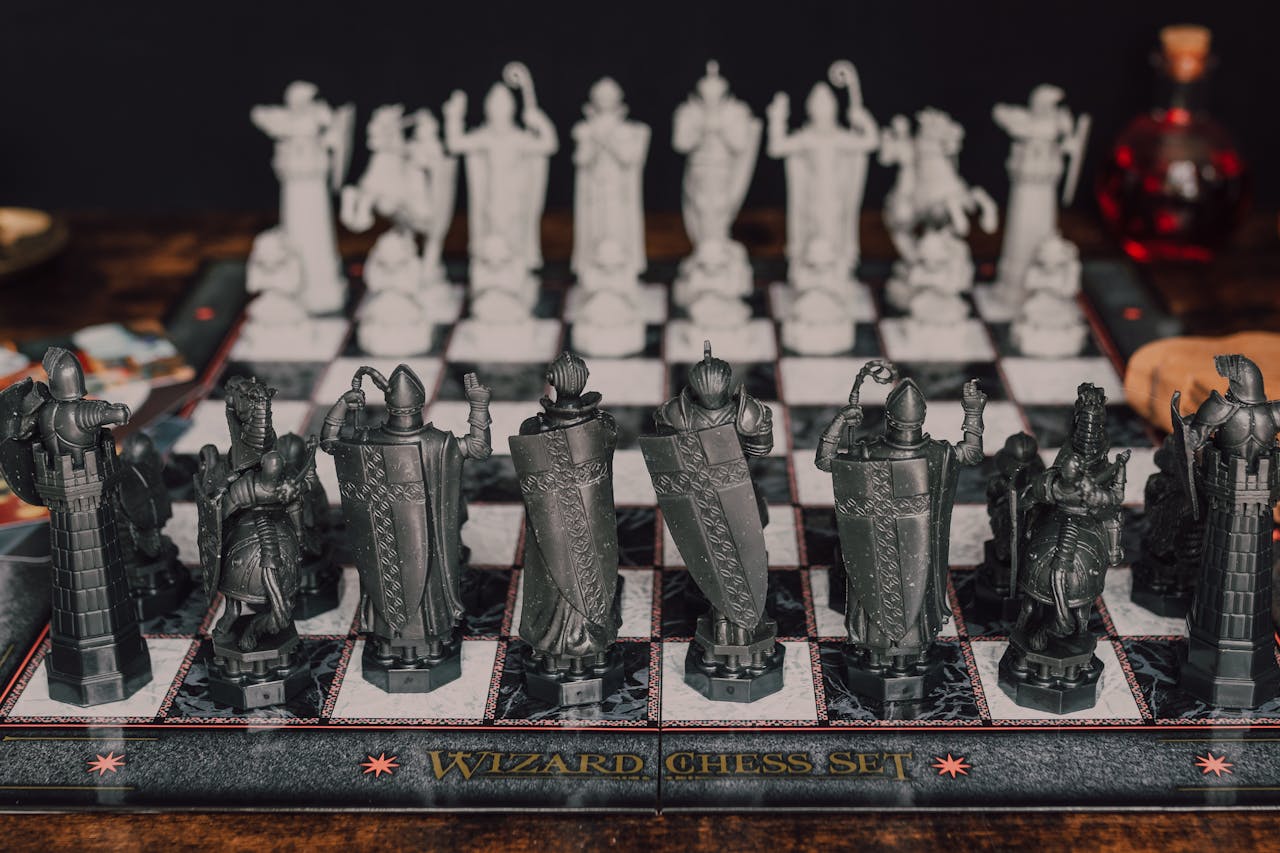 Close-up of a fantasy-themed wizard chess set featuring intricate black and white pieces.