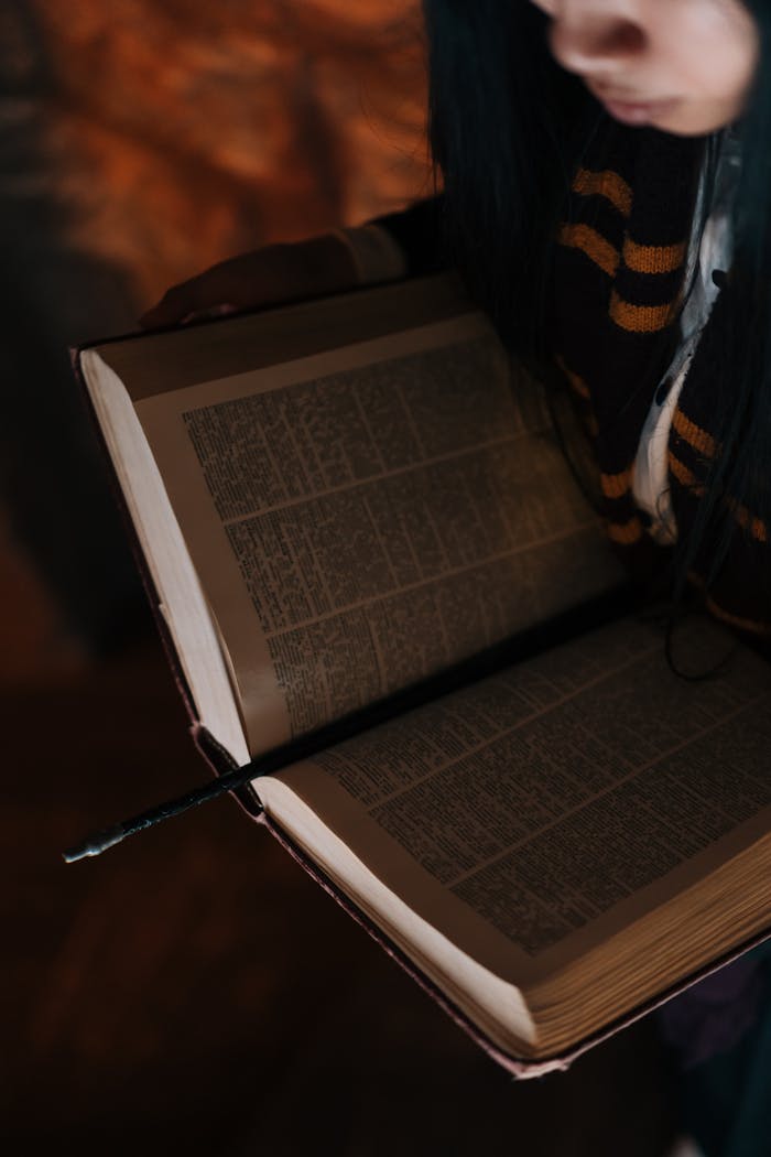A mystical scene with an open book and a wand, suggesting witchcraft or magic.
